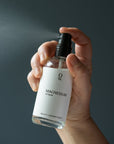 Hand houdt een flesje magnesiumspray vast terwijl er spray uit komt. Ondersteunt huidtoepassing van magnesium, ontspanning van spieren, spierherstel, betere slaap en een gezonde magnesiumbalans. Verkrijgbaar in onze magnesium webshop.