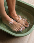 Foto van voeten die ontspannen in een magnesium voetenbad met oplosbare magnesiumvlokken. Ondersteunt spierontspanning, stressvermindering en een gezonde magnesiumbalans voor welzijn en selfcare.