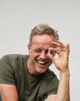 Man met Magnesium glicinaat capsule tussen vingers met glimlach
