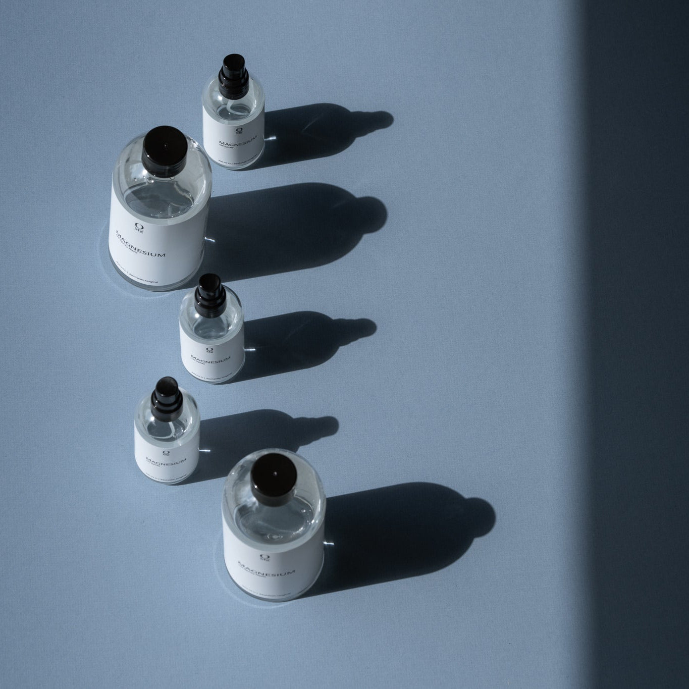 Foto van een magnesiumflesje dat naast een grotere hervulfles staat. Op onze website kun je eenvoudig dit magnesiumproduct kopen en bijvullen, voor dagelijkse suppletie, spierontspanning en ondersteuning van de magnesiumbalans.