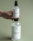 Foto van een voordelige 500ml navul fles magnesiumolie waarop een 100ml magnesiumolie sprayflesje wordt geplaatst. Praktische mgnesium olie set voor dagelijks gebruik en eenvoudig navullen, direct verkrijgbaar in onze webshop.