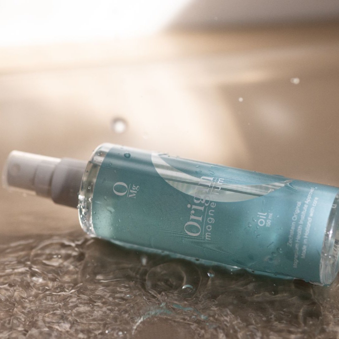 Oil bottle with drops of Origin Magnesium in a bath