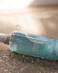 Oil bottle with drops of Origin Magnesium in a bath
