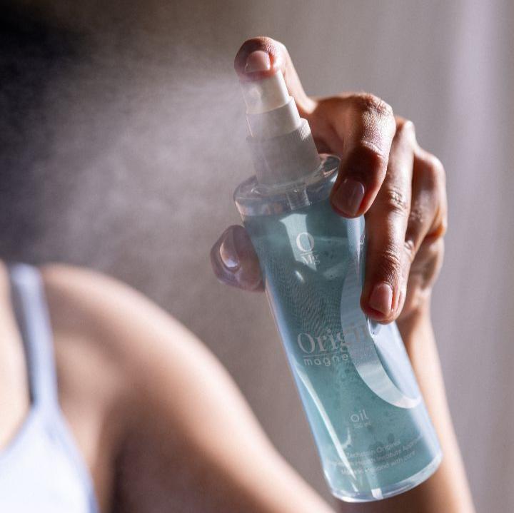 Female spraying magnesium oil from a bottle