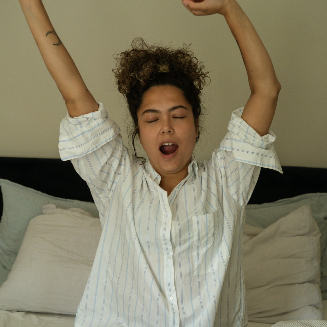 Foto van een vrouw die ’s ochtends wakker wordt en een magnesiumcapsule inneemt voor een gezond begin van de dag. Magnesium ondersteunt energie, welzijn, spierontspanning en dagelijkse magnesiumbalans voor optimale gezondheid en vitaliteit.