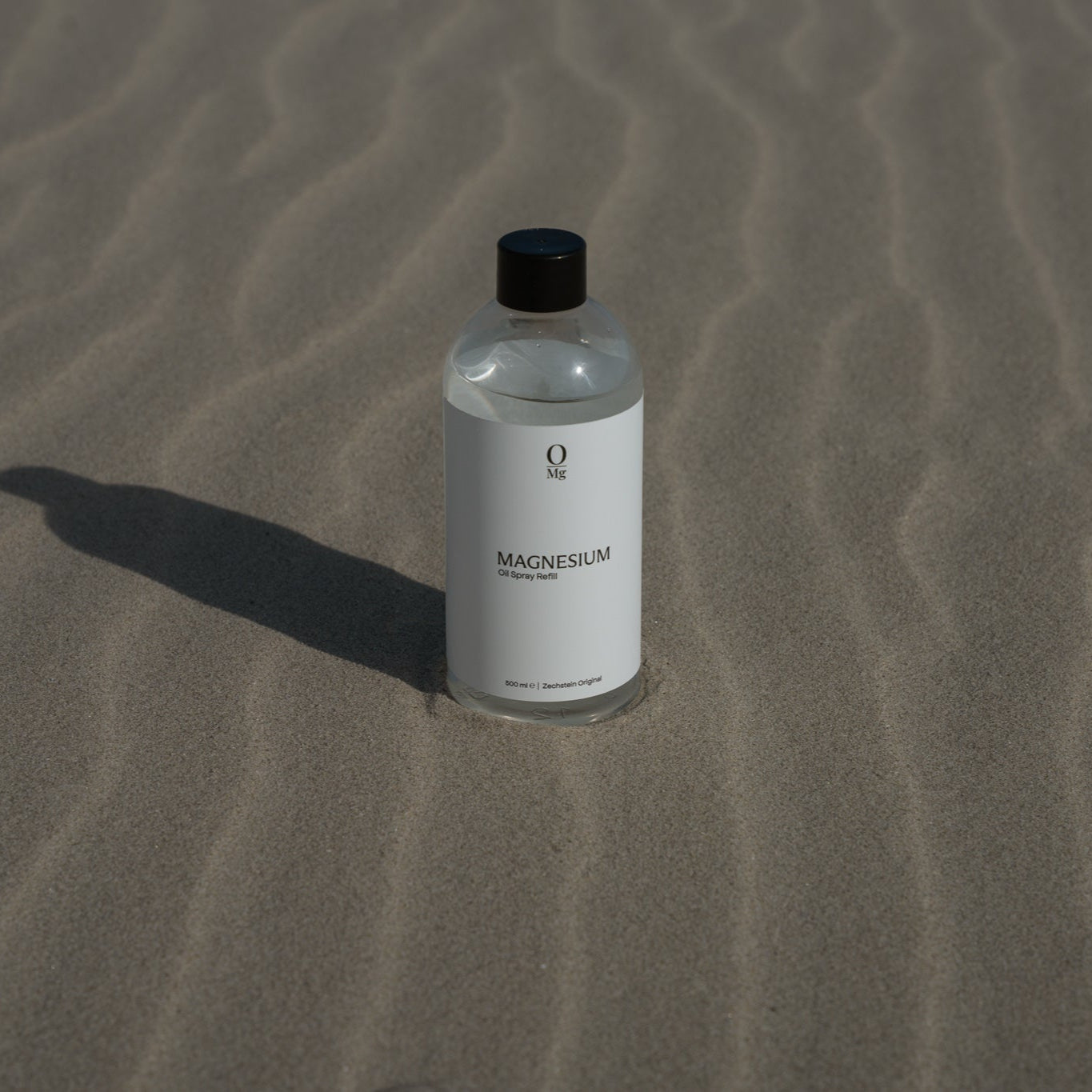 Foto van onze Zechstein 500ml magnesium navulfles in de branding op het strand. Ondersteunt diepe slaap, ontspanning van spieren, gezonde stressniveaus, stabiele bloedsuikers, hart- en botgezondheid en kan helpen bij PMS en hormonale balans. Eenvoudig te bestellen via onze webshop.
