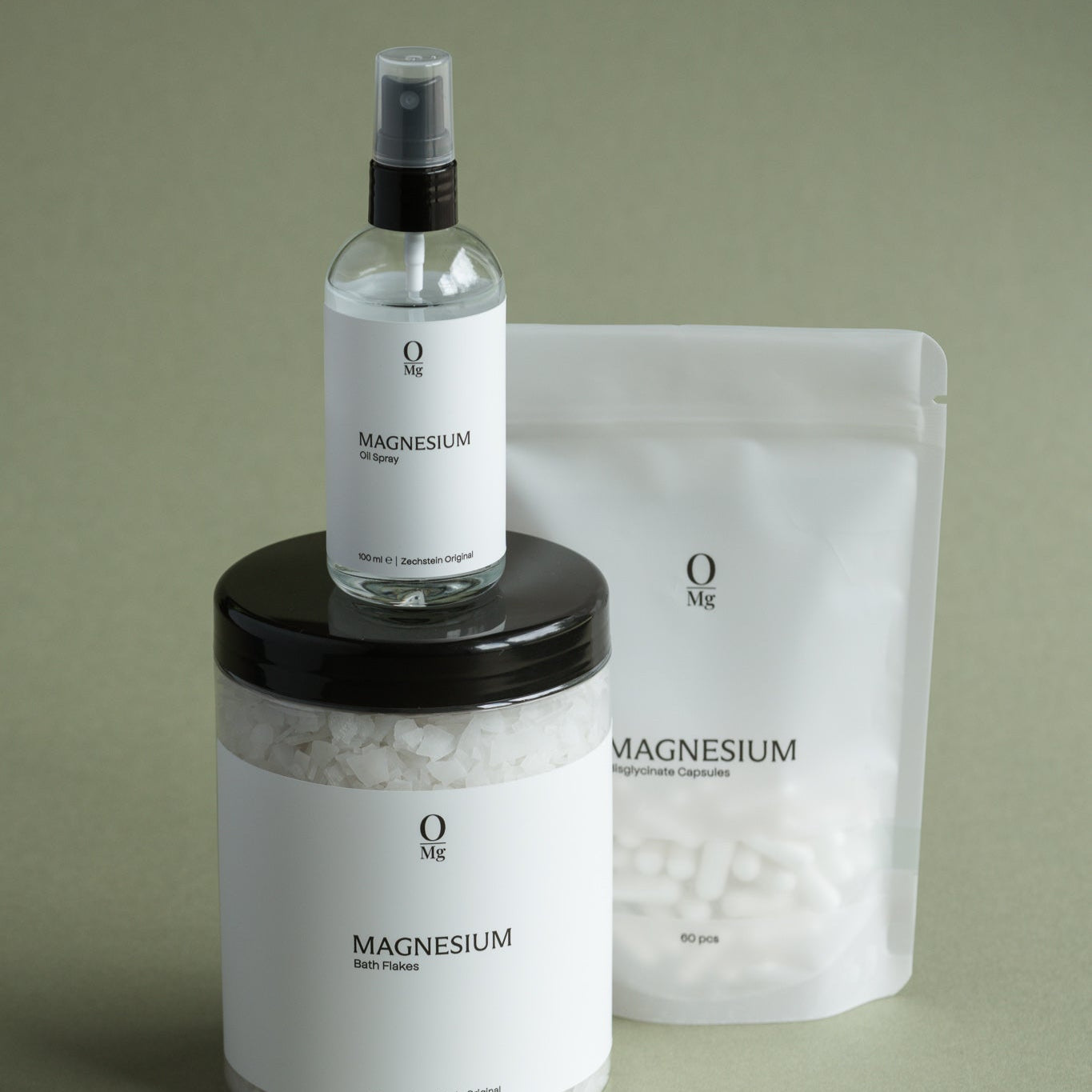 Foto van ons complete magnesiumassortiment naast elkaar: magnesiumolie voor huidtoepassing, oplosbare magnesiumvlokken voor ontspannende baden, en magnesiumcapsules voor dagelijkse suppletie. Ondersteunt spierontspanning, stressvermindering en een gezonde magnesiumbalans